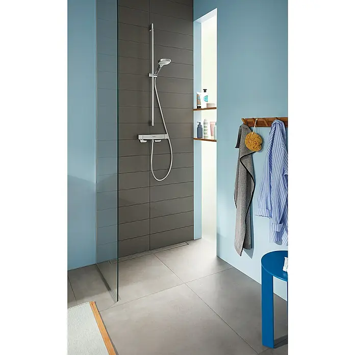 Hansgrohe Croma Select S Brausegarnitur 110 Vario - Lochabstand: 91,5 cm, Art Strahl: Rain, TurboRain, IntenseRain, Chrom/Weiß, Wassersparfunktion - Modernes Badezimmer mit grauen Fliesen, Duschkopf und Armaturen. Handtuchhalter und blauer Hocker ergänzen das stilvolle Design.