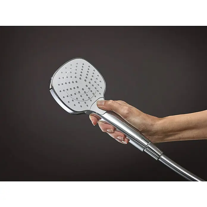 Hansgrohe Croma Select E Brausegarnitur 110 Vario - Lochabstand: 91,5 cm, Art Strahl: Rain, TurboRain, IntenseRain, Chrom/Weiß, Wassersparfunktion - Handbrause: Eine Hand hält eine quadratische, verchromte Handbrause vor einem dunklen Hintergrund.