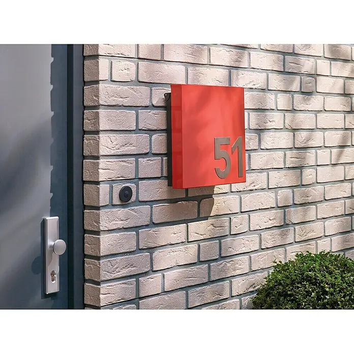 Tesa Powerbond Cinta de doble cara Ladrillo/Piedra - 1,9 cm x 5 m - Un buzón rojo con el número 51 en una pared de ladrillo, junto a una puerta gris y un pomo.