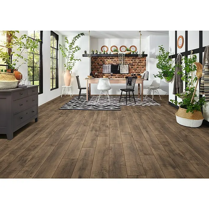 LOGOCLIC Aquaprotect Smart Laminat - Tyri Oak, Landhausdiele, 1.288 x 195 x 6 mm - Innenaufnahme eines Zimmers mit Holzböden, einem Esstisch und grünen Pflanzen für ein gemütliches und natürliches Ambiente.