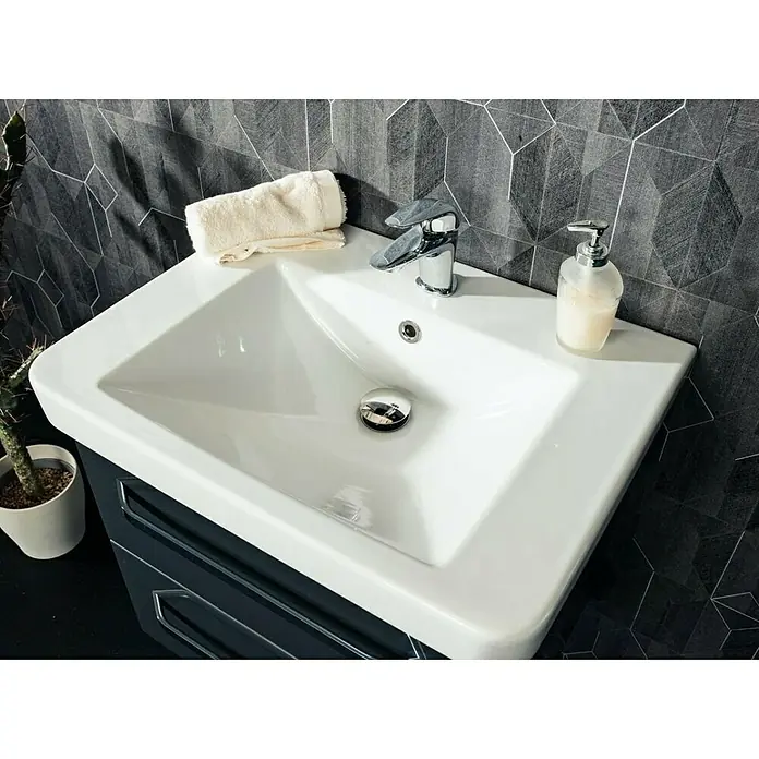 Lanzet K2 Einbauwaschbecken64 x 48 cm, Weiß - Ein modernes Waschbecken mit Armatur, Seifenspender und Handtuch präsentiert ein stilvolles Badezimmer-Ambiente mit geometrischem Fliesendesign.