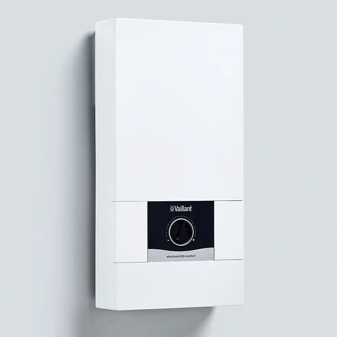 Vaillant Durchlauferhitzer VED E 21/8C COMFORT - 21 kW, Elektronisch, Geschlossen - Ein weißer Vaillant electronicVED Comfort Warmwasserbereiter hängt an einer hellgrauen Wand.