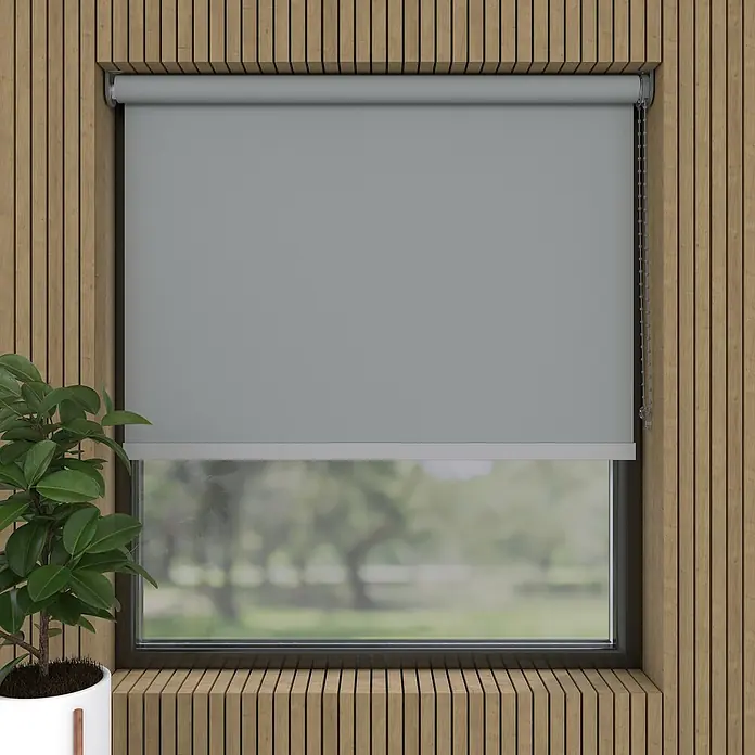 Expo Ambiente Verdunkelungsrollo Mila - B x H: 210 x 190 cm, Hellgrau - Ein graues Rollo ist vor einem Fenster mit Blick auf einen Garten geschlossen, um Privatsphäre und Schatten zu gewährleisten. Die Holzverkleidung sorgt für Wärme.