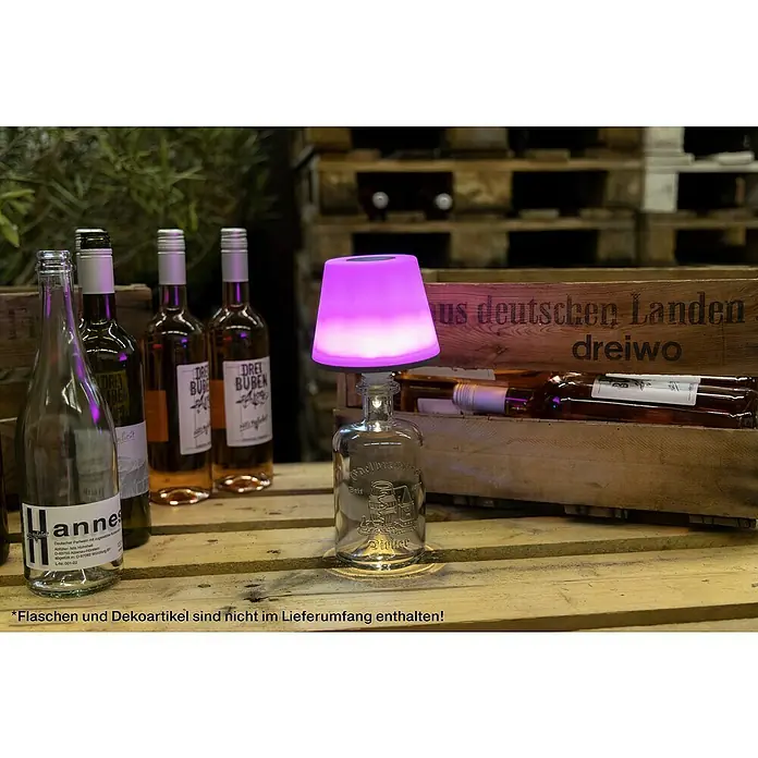 REV LED-Flaschenleuchte mit Akku Lamprusco - 2 W, RGBW, Ø x H: 11,5 x 13,8 cm, Weiß, Akkubetrieben - Nahaufnahme einer dekorativen Flaschenlampe mit violettem Schirm, umgeben von Weinflaschen auf einer Holzpalette.