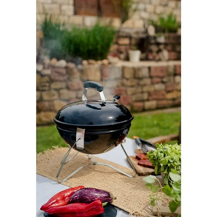 Kingstone Kugelgrill Cutie Pie - Durchmesser Grillfläche: 37 cm, Schwarz - Ein tragbarer, schwarzer Kugelgrill mit Gemüse im Vordergrund steht bereit für ein köstliches Grillfest im Freien.