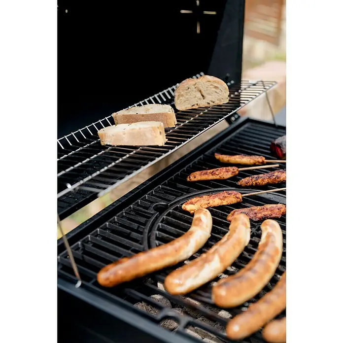 Kingstone KMS Holzkohlegrill Black Angus XXL - Grillfläche (B x T): 70 x 43,5 cm, Schwarz - Nahaufnahme von köstlichen Würstchen und Brot, die auf einem Grill zubereitet werden, ein Fest für Feinschmecker im Freien.