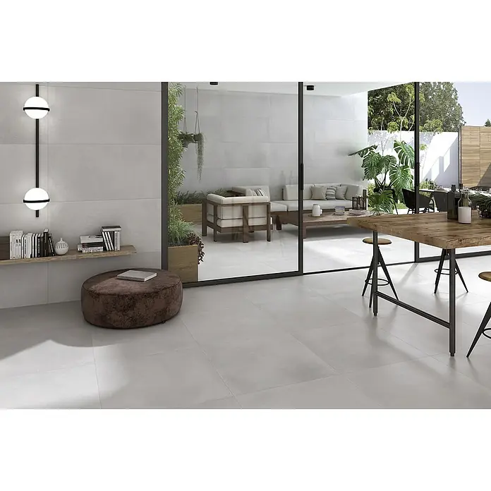 Pavimento porcelánico Energy - 60 x 60 cm, Blanco, Mate, Rectificado - Esta imagen muestra baldosas modernas en un tono gris claro, creando un interior elegante con conexión a la zona exterior. Tiene una apariencia muy elegante.