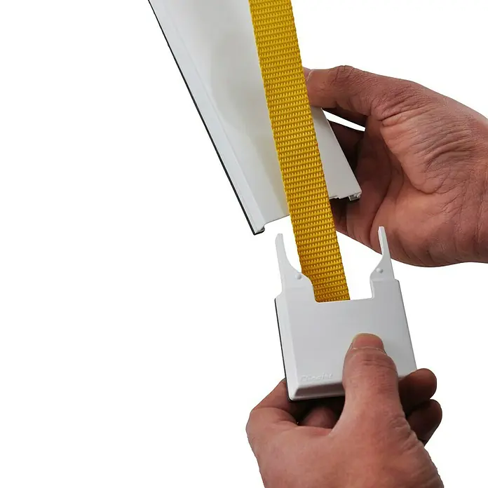 Embellecedor ClicArt® BA2 Flor - Plástico, Gris - Primer plano de una mano que engancha una correa amarilla en un clip blanco sobre una varilla blanca.