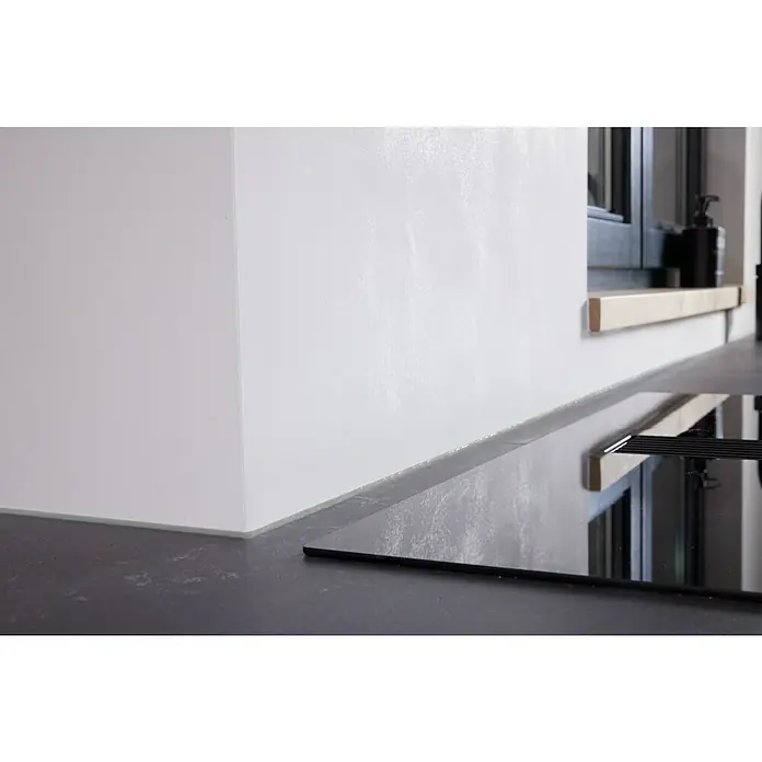 UHU Poly Max Montagekleber Power - Grau, 425 g, Kartusche - Nahaufnahme eines modernen schwarzen Kochfelds in einer stilvollen Küche mit weißer Wand und Fenster.