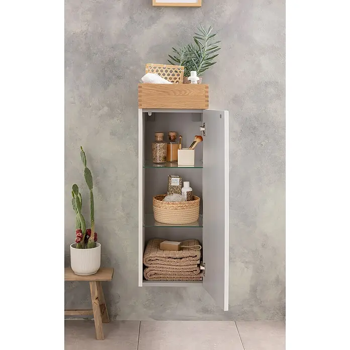 Camargue Nature Midischrank - 30 x 31,8 x 92 cm, Weiß/Eiche, DIN Anschlag: Rechts - Ein Badezimmerschrank mit Glasböden ist mit Handtüchern, Körben und verschiedenen Badezimmerartikeln gefüllt. Auf dem Schrank steht ein Holzbehälter.