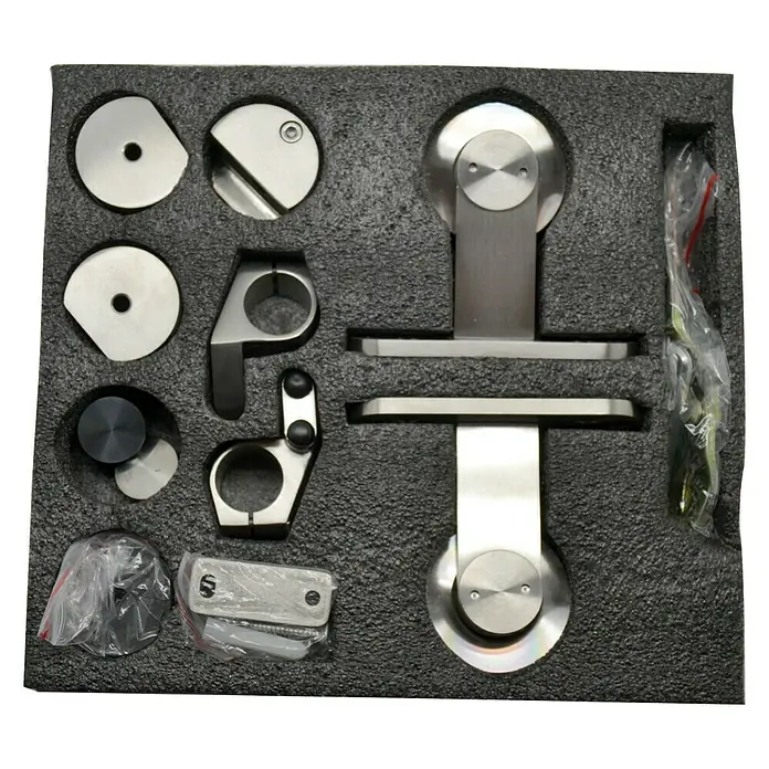 Set completo de herrajes para puertas correderas de madera - Capacidad de carga: 150 kg - Primer plano de accesorios de acero inoxidable para puertas correderas, dentro de un embalaje de espuma negra.