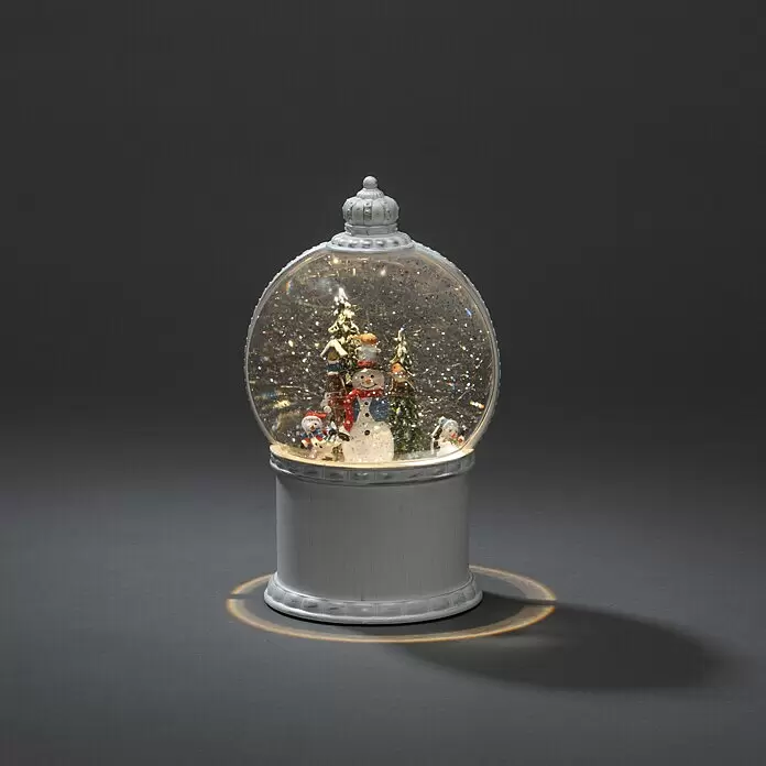 Konstsmide LED-Schneelaterne Schneemann mit Baum - Innen, Altweiß, 12,5 x 12,5 x 21 cm, Schneemann mit Christbaum, Batteriebetrieben - Weiße Schneekugel mit beleuchteter Winterszene von Schneemännern und Bäumen, gefüllt mit Glitzer und einem warmen Schein.