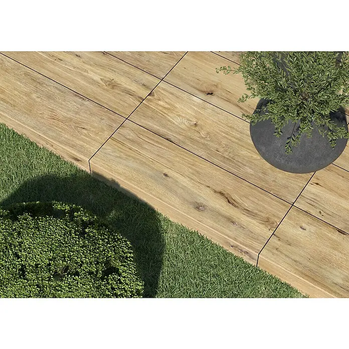Terrassenfliese Garden Rustbrown 2.0 - 39,7 x 119,7 x 2 cm, Braun, Matt - Nahaufnahme von Holzfliesen mit Gras und Pflanze im Topf. Die Fliesen haben eine natürliche Holzmaserung und eine glatte Oberfläche.