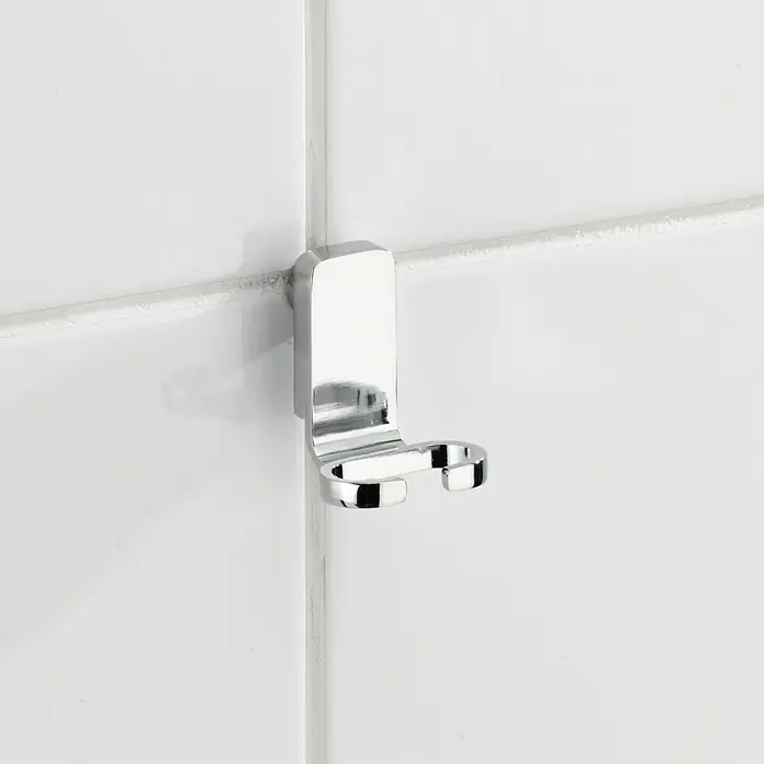 Wenko Limpiamamparas para baño y ducha Premium - Cromo - Un primer plano de un brillante portacepillos de dientes cromado montado en una pared de azulejos blancos, perfecto para accesorios de baño.