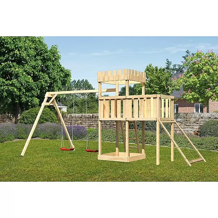 Karibu Kinderspielturm Ritterburg Löwenherz Set 43 - L x B x H: 264 x 454 x 259,5 cm, Natur - Hölzernes Spielgerüst mit Burgturm, Kletterrampe und zwei roten Schaukeln in einem grünen Garten.