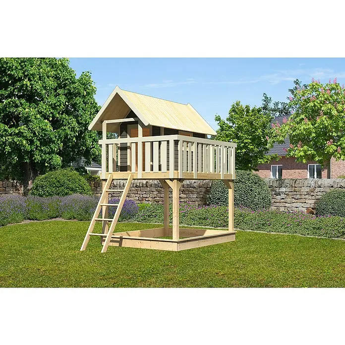 Karibu Kinderspielturm Fidel Set 2 - L x B x H: 243 x 198 x 329,5 cm, Natur - Ein hölzernes Spielhaus mit Sandkasten im Garten. Das Spielhaus hat eine Leiter und ein Geländer. Es steht auf einer grünen Wiese mit Bäumen.