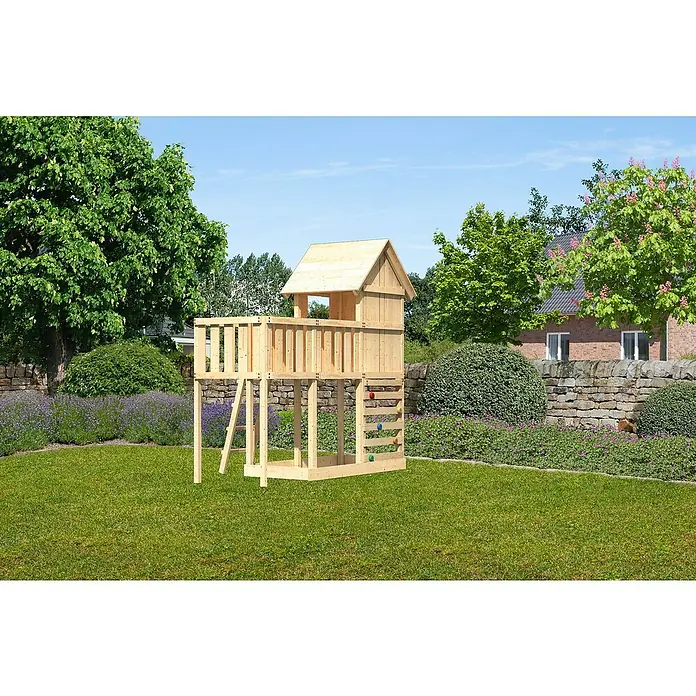 Karibu Kinderspielturm Frieda Set 26 - L x B x H: 107 x 309 x 291 cm, Natur - Ein hölzernes Spielhaus mit Kletterwand und Leiter steht auf einem grünen Rasen. Es bietet Kindern einen tollen Ort zum Spielen im Freien.