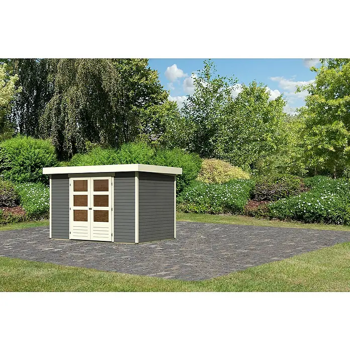 Karibu Gartenhaus Cuno 4 - Außenmaß inkl. Dachüberstand (B x T): 330 x 238 cm, Holz, Terragrau - Ein modernes Gartenhaus mit Doppeltür, eingebettet in eine grüne Umgebung. Die dunkle Holzverkleidung kontrastiert mit den hellen Türrahmen.