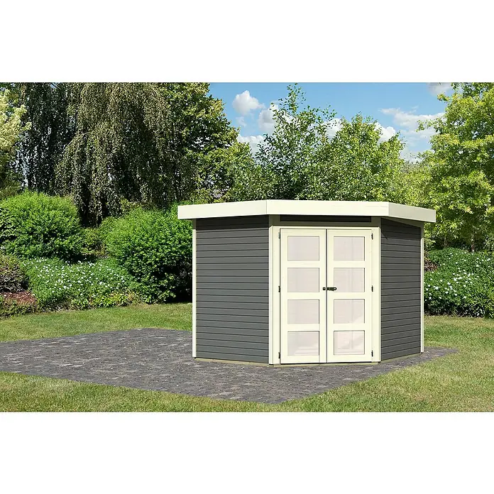Karibu Gartenhaus Goldendorf 5Außenmaß inkl. Dachüberstand (B x T): 268 x 262 cm, Holz, Terragrau, Ohne Seitendach - Ein modernes Gartenhaus mit grauen Holzwänden, einer weißen Tür und einem Flachdach steht auf einem gepflasterten Bereich vor üppigem Grün.