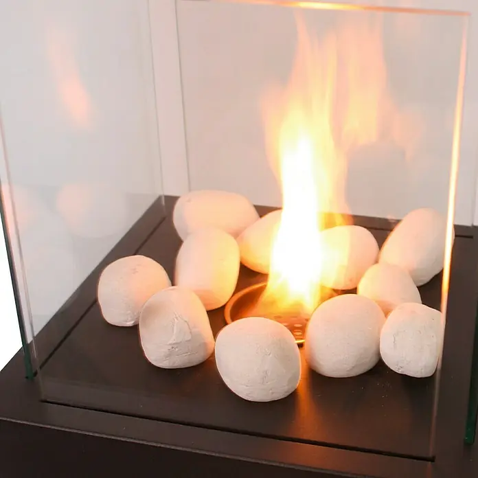 Purline Piedras decorativas de cerámica para Biochimeneas - Blanco, 24 ud. - Primer plano de un brasero de mesa con piedras decorativas y marco de vidrio.