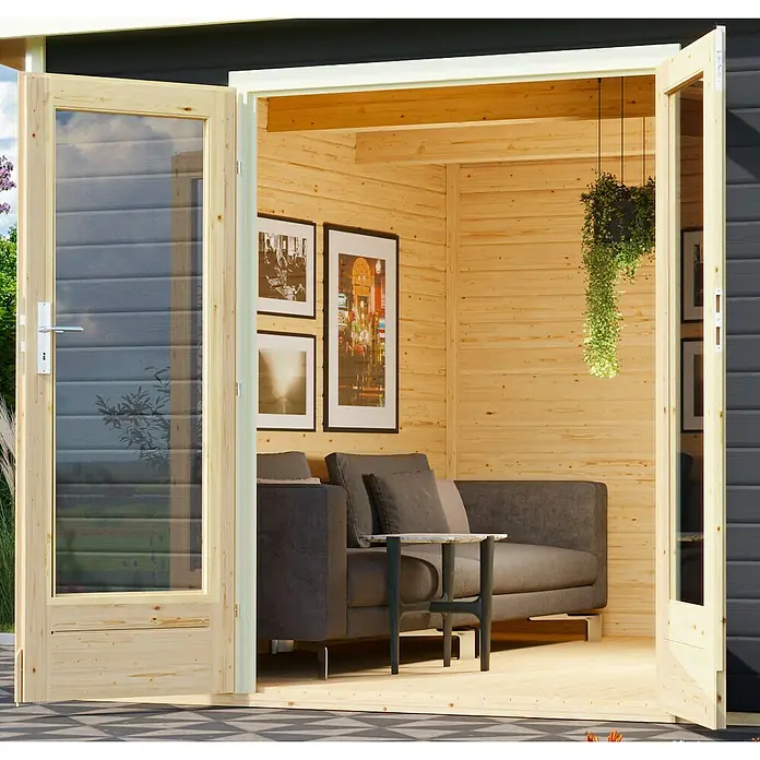 Karibu Gartenhaus Radeburg 5 - Außenmaß inkl. Dachüberstand (B x T): 560 x 422 cm, Holz, Terragrau - Einladendes Gartenhaus mit Doppeltür und gemütlicher Inneneinrichtung mit Sofa, Tisch und hängender Pflanze.