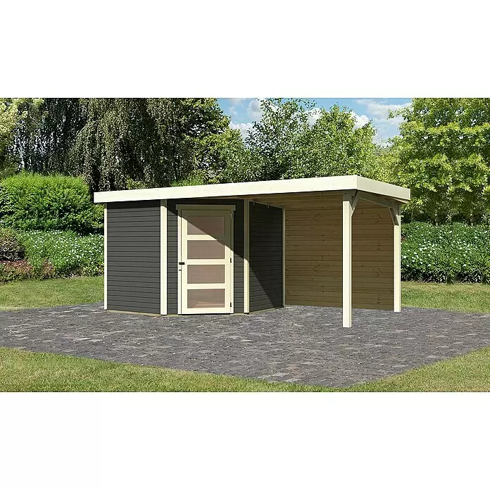 Karibu Gartenhaus Schwandorf 5 - Außenmaß inkl. Dachüberstand (B x T): 492,5 x 262 cm, Holz, Terragrau, Mit Seitendach und Rückwand - Dunkelgrauer Geräteschuppen mit heller Holztür, Zierleisten und angebautem Naturholz-Carport, auf einem gepflasterten Patio.