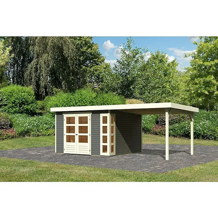 Karibu Gartenhaus Kerko 6 - Außenmaß inkl. Dachüberstand (B x T): 558 x 331 cm, Holz, Terragrau, Mit Seitendach - Ein graues Gartenhaus mit einem kleinen Vordach und weißen Rahmen auf einer gepflasterten Fläche, umgeben von viel Grün.