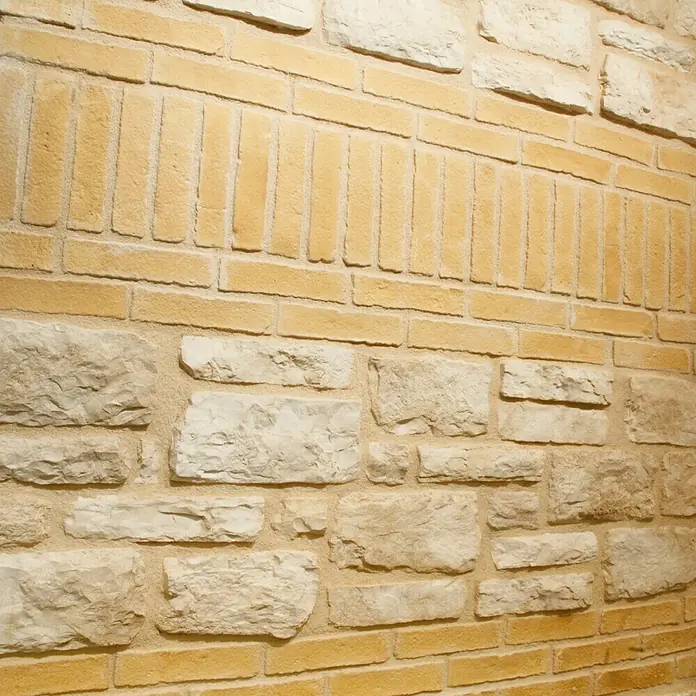 Revestimiento de piedra Mediterráneo Barro - 24 x 5,5 x 2,5 cm - Primer plano de una pared de ladrillo con diversos patrones y texturas de piedra, destacando su diseño versátil.