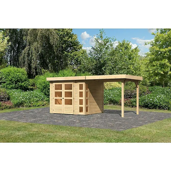 Karibu Gartenhaus Kerko 3Außenmaß inkl. Dachüberstand (B x T): 491 x 238 cm, Holz, Natur, Mit Seitendach - Holzschuppen mit angrenzendem Carport auf gepflasterter Fläche, umgeben von Grün. Ideal für Gartenutensilien und als Unterstand.