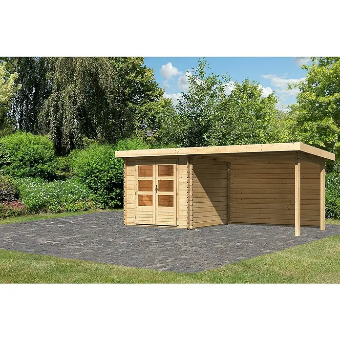Karibu Gartenhaus Bastrup 2Außenmaß inkl. Dachüberstand (B x T): 554 x 273 cm, Holz, Natur, Mit Seitendach und Rückwand - Ein modernes Holzgartenhaus mit Flachdach und einer überdachten Fläche auf einer gepflasterten Terrasse im Grünen.
