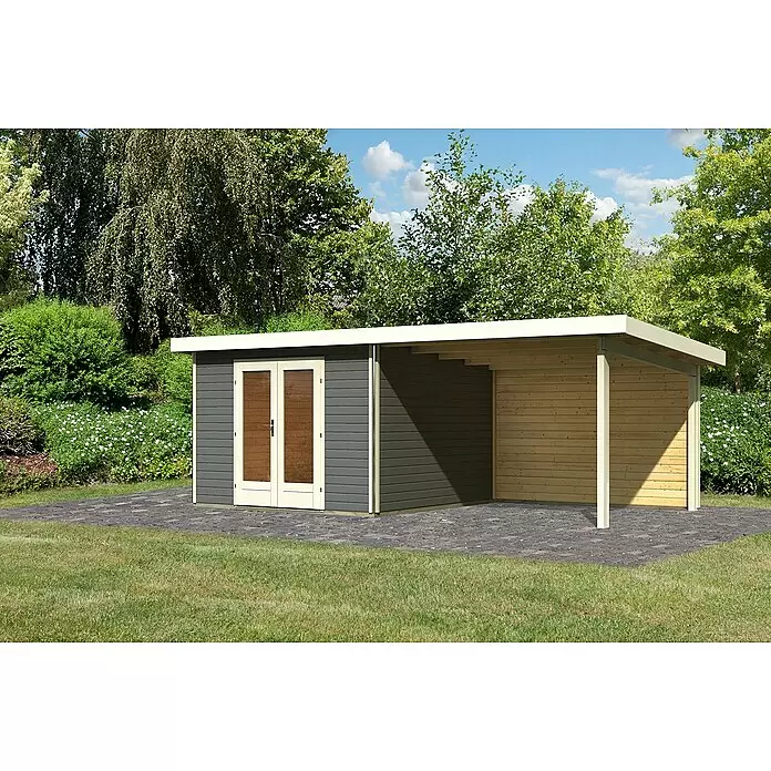 Karibu Gartenhaus Radeburg 1 - Außenmaß inkl. Dachüberstand (B x T): 664 x 331,5 cm, Holz, Terragrau, Mit Seitendach und Rückwand - Modernes anthrazitfarbenes Gartenhaus mit hellem Anbau und integriertem Holzcarport auf gepflasterter Terrasse im Garten.