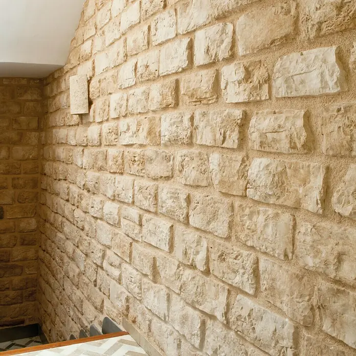 Revestimiento de piedra Silleria Cobre - Cobre, Cantidad total: 4 pzs. - Primer plano de una pared de piedra rústica con bloques irregulares y mortero visible, mostrando una textura cálida y natural.