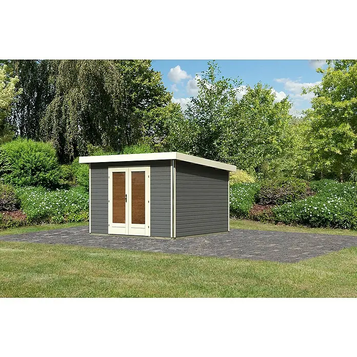 Karibu Gartenhaus Radeburg 1 - Außenmaß inkl. Dachüberstand (B x T): 346 x 331,5 cm, Holz, Terragrau - Ein graues Gartenhaus mit doppelten Türen, umgeben von Grün und einem gepflasterten Bereich, bietet stilvollen Stauraum für den Außenbereich.