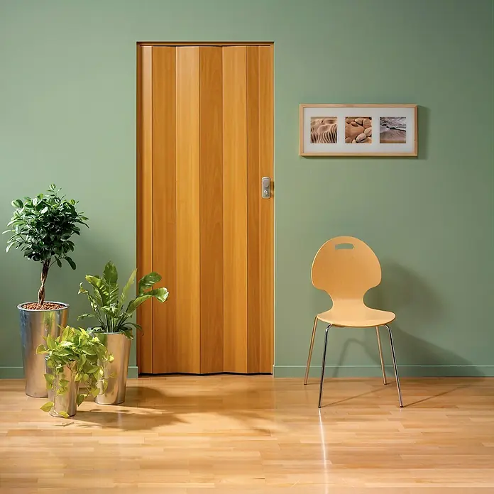Grosfillex Puerta plegable Spacy - 84 x 205 cm, Marrón claro - Escena acogedora con una puerta plegable de madera clara, que añade calidez y funcionalidad a un interior elegante.