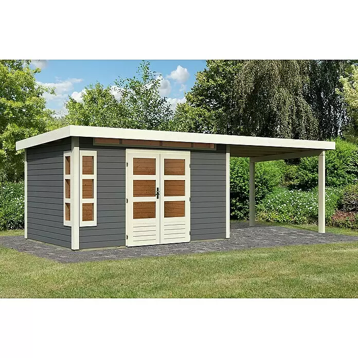 Karibu Gartenhaus Kastorf 7 - Außenmaß inkl. Dachüberstand (B x T): 702 x 273 cm, Holz, Terragrau, Mit Seitendach - Dunkelgrauer Geräteschuppen mit hellem Rahmen und Holzeinsätzen an Türen, mit angebautem Carport, auf gepflastertem Bereich im Garten.