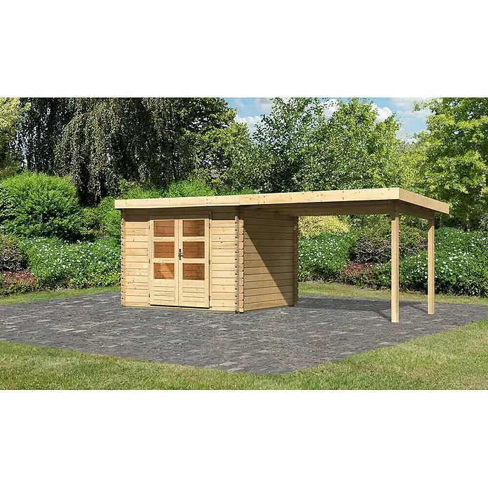 Karibu Gartenhaus Bastrup 3Außenmaß inkl. Dachüberstand (B x T): 614 x 273 cm, Holz, Natur, Mit Seitendach - Außenaufnahme eines Holzschuppens mit einem angebauten Carport vor dem Hintergrund eines Gartens mit Bäumen und Blumen.