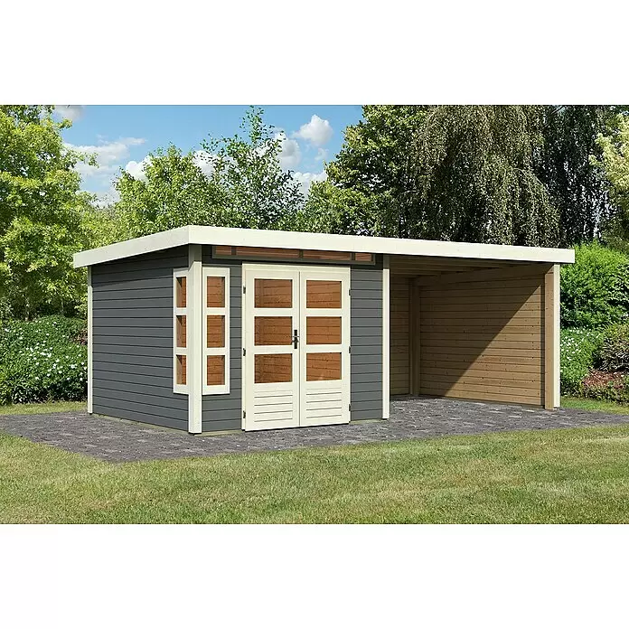 Karibu Gartenhaus Kastorf 6 - Außenmaß inkl. Dachüberstand (B x T): 612 x 303 cm, Holz, Terragrau, Mit Seitendach, Rück- und Seitenwand - Dunkelgraues Gartenhaus mit hellen Holztüren und angebautem naturbraunem Carport auf Pflastersteinen im Garten.