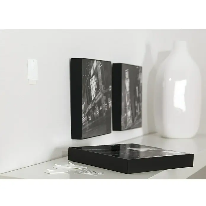 Tesa Powerstrips Gancho autoadhesivo para cuadros - 2 ud., Blanco - La imagen muestra tiras Command, una forma fácil de colgar decoraciones en las paredes sin causar daños.