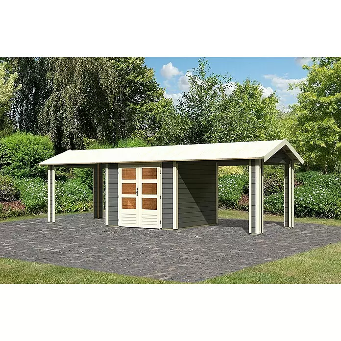 Karibu Gartenhaus Theres - Außenmaß inkl. Dachüberstand (B x T): 767 x 288 cm, Holz, Terragrau - Dunkelgraues Gartenhaus mit cremefarbenen Türen und Carport auf gepflasterter Terrasse im Garten.