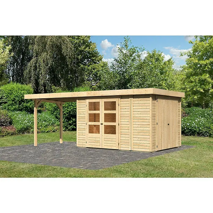 Karibu Gartenhaus Retola 4 - Außenmaß inkl. Dachüberstand (B x T): 603,5 x 262 cm, Holz, Natur - Holzgartenhaus mit Anbau auf gepflastertem Untergrund, umgeben von Bäumen und Grünflächen. Ideal zur Aufbewahrung und als Unterstand.