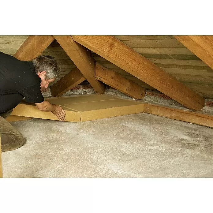 Steico Holzfaserdämmplatte top - 1.200 x 400 mm, Stärke: 80 mm, Wärmeleitfähigkeit: 0,04 W/(mK) - Eine Person installiert hellbraune Dämmplatten auf einem Dachboden zur Verbesserung der Wärmedämmung.