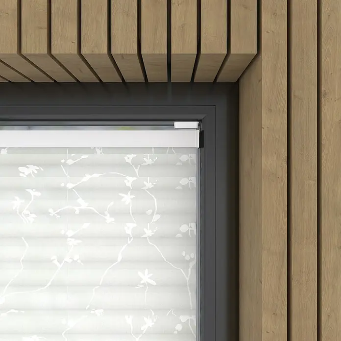Expo Ambiente Plissee Blüte - B x H: 80 x 130 cm, Grau/Weiß - Ein Fenster mit einem eleganten, weißen Rollo mit floralem Muster, eingebettet in eine moderne Holzverkleidung.