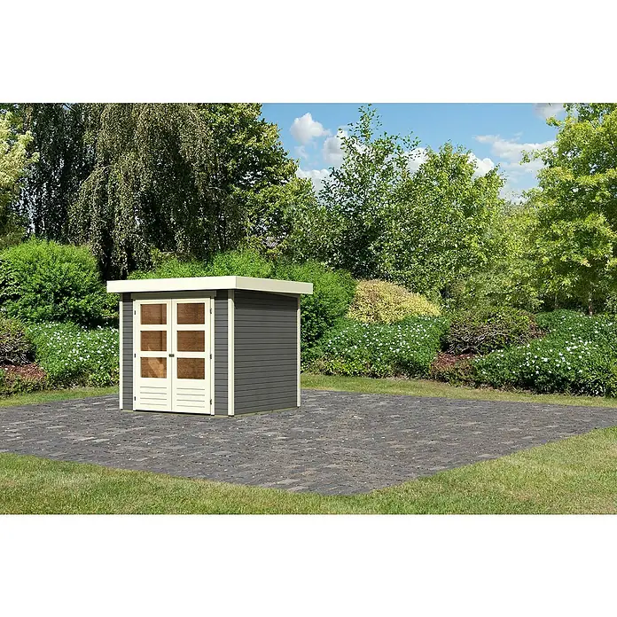 Karibu Gartenhaus Cuno 1 - Außenmaß inkl. Dachüberstand (B x T): 242 x 238 cm, Holz, Terragrau - Ein modernes Gartenhaus in Grau und Weiß mit Doppeltüren auf gepflastertem Untergrund, umgeben von Grünpflanzen und Bäumen.