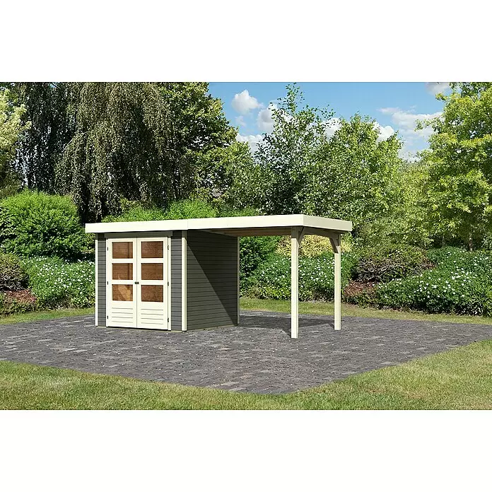 Karibu Gartenhaus Cuno 1 - Außenmaß inkl. Dachüberstand (B x T): 467 x 238 cm, Holz, Terragrau, Mit Seitendach - Dunkelgrauer Geräteschuppen mit beigem Rand und Türen, mit angeschlossenem beigem Carport, auf einem gepflasterten Bereich in einem Garten.