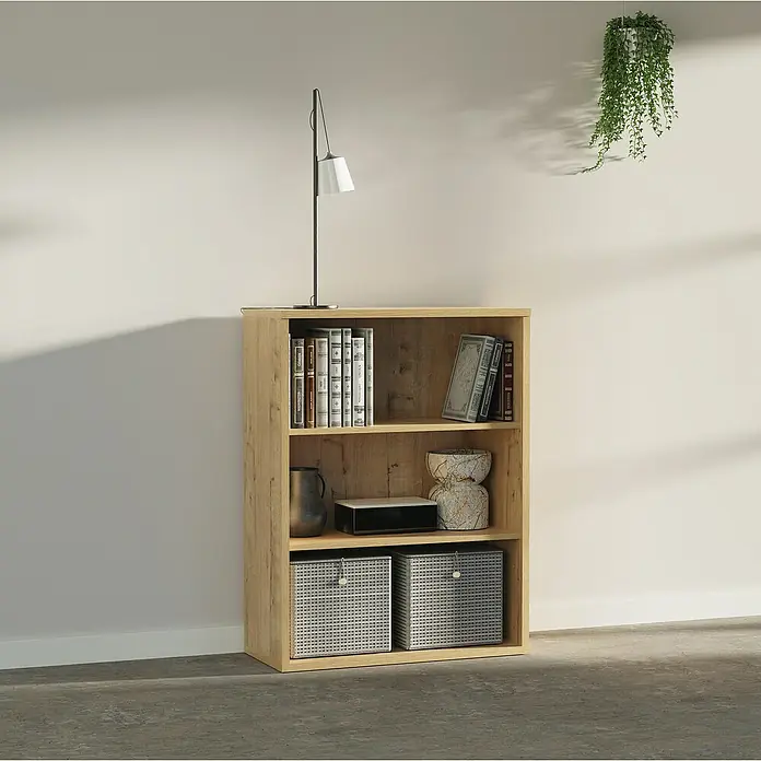 Muebles Pitarch Estantería de madera - Al x An x Pr: 99,5 x 75,5 x 33 cm, Número de baldas: 3 ud., Roble - Una estantería de madera clara con tres estantes llenos de libros, cestas y objetos decorativos, debajo de una lámpara y una planta colgante.