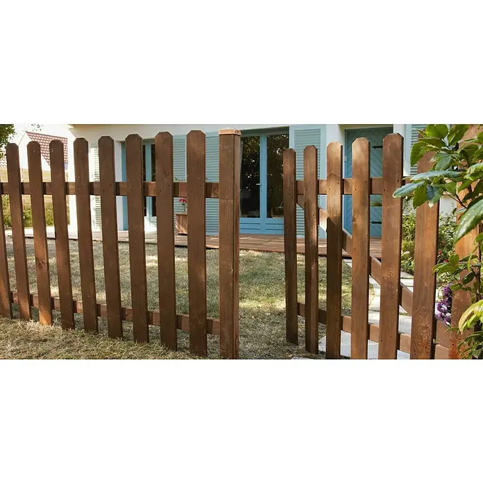 Cerland Valla de madera Mustang - L x Al: 180 x 100 cm, Marrón - Una cerca de madera marrón rodea una casa con puertas y ventanas pintadas de azul, ofreciendo seguridad y privacidad.