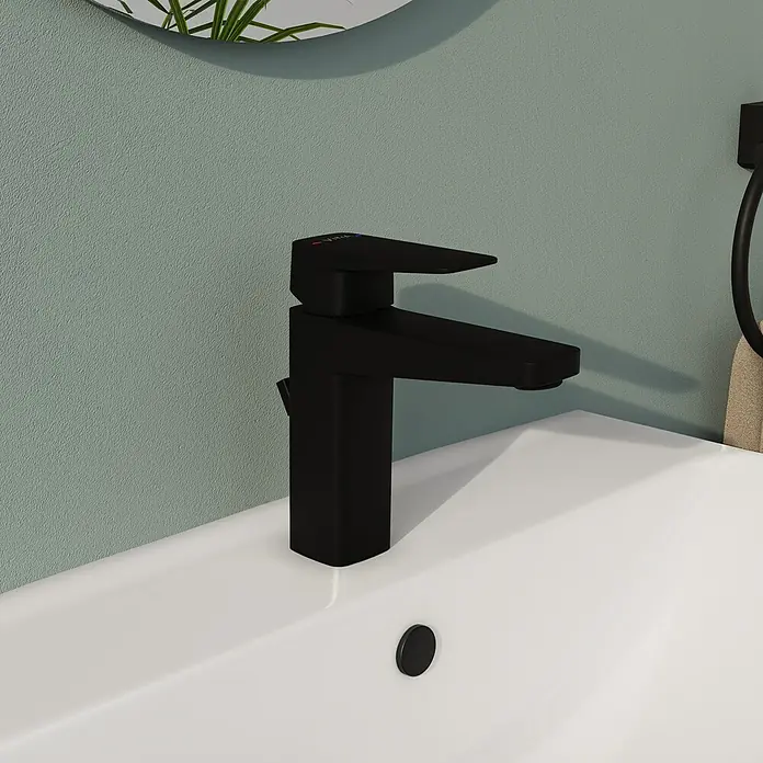 VitrA Überlaufrosette - Schwarz, Passend für: Waschtische mit rundem Überlaufloch - Nahaufnahme einer modernen, schwarzen Armatur auf einem weißen Waschbecken, die ein elegantes Baddesign hervorhebt.