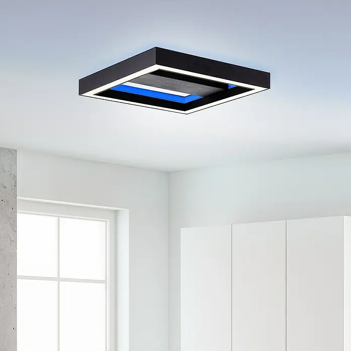 Brilliant LED-Panel Icarus - L x B x H: 30 x 30 x 5,7 cm, 18 W, Schwarz, Warmweiß - Eine quadratische, moderne Deckenleuchte in Schwarz mit blauer Akzentbeleuchtung in einem hellen Raum.