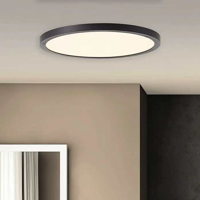 Brilliant LED-Panel rund Tuco - 16 W, Ø x H: 25 x 2,1 cm, Schwarz, Weiß - Nahaufnahme einer runden LED-Deckenleuchte mit dunklem Rahmen, die ein sanftes, warmes Licht in einem modernen Raum ausstrahlt.