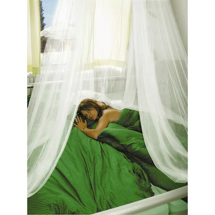 Schellenberg Mosquito Net Mosquitera Standard - An x Al: 200 x 85 cm, Montaje de la mosquitera: Colgar - Mujer acostada en una cama con dosel con ropa de cama verde. El mosquitero ligero y aireado contribuye a un ambiente tranquilo y relajante.